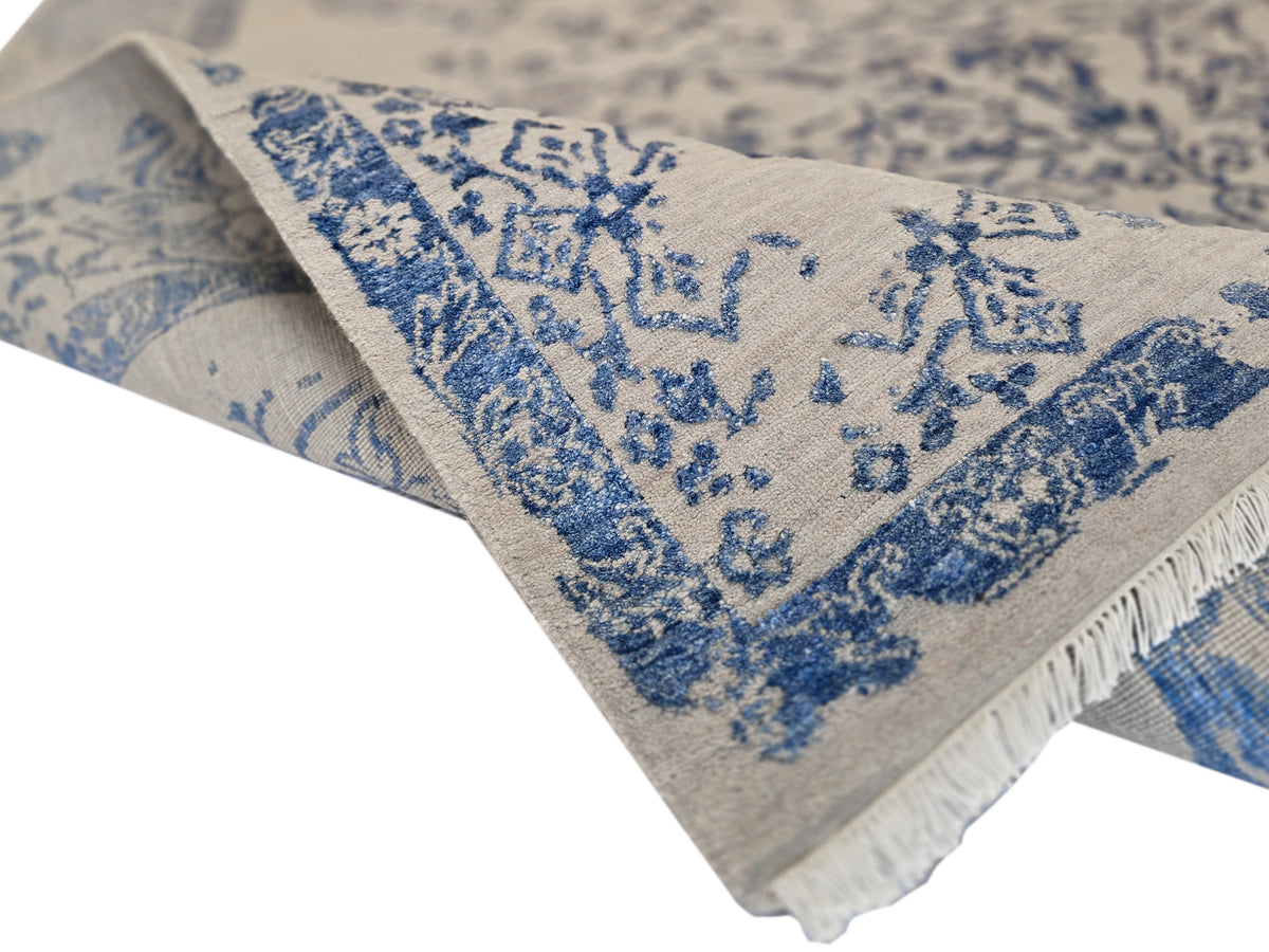 Modern rug 310x244 cm with blue patterned center and fringed edge on light base