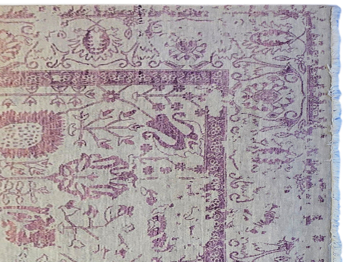 Modern beige rug with purple border and ornate design, frayed fringe detail