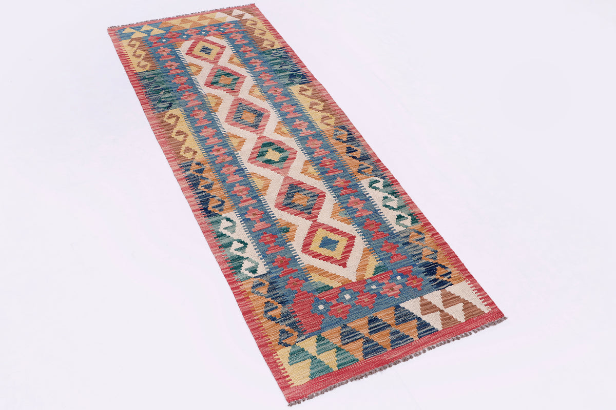Multicolor kilim rug laid flat on light background, geometric diamond border design