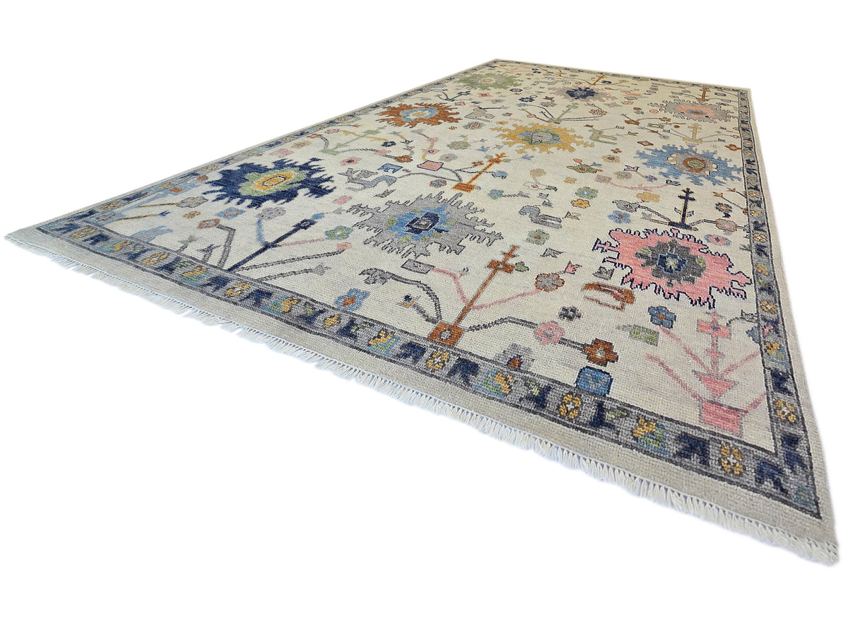 Oushak rug with light beige base, navy and blue border, and multicolor scattered motifs