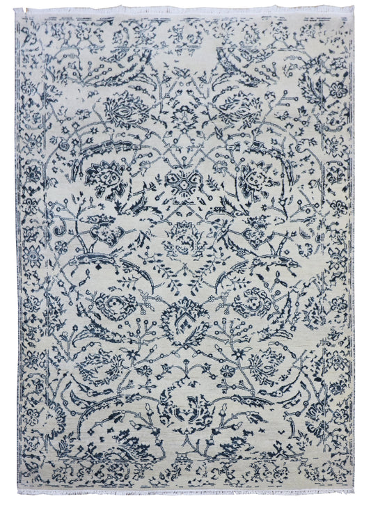 Delft blue and off-white area rug with dense floral scroll pattern and central medallion