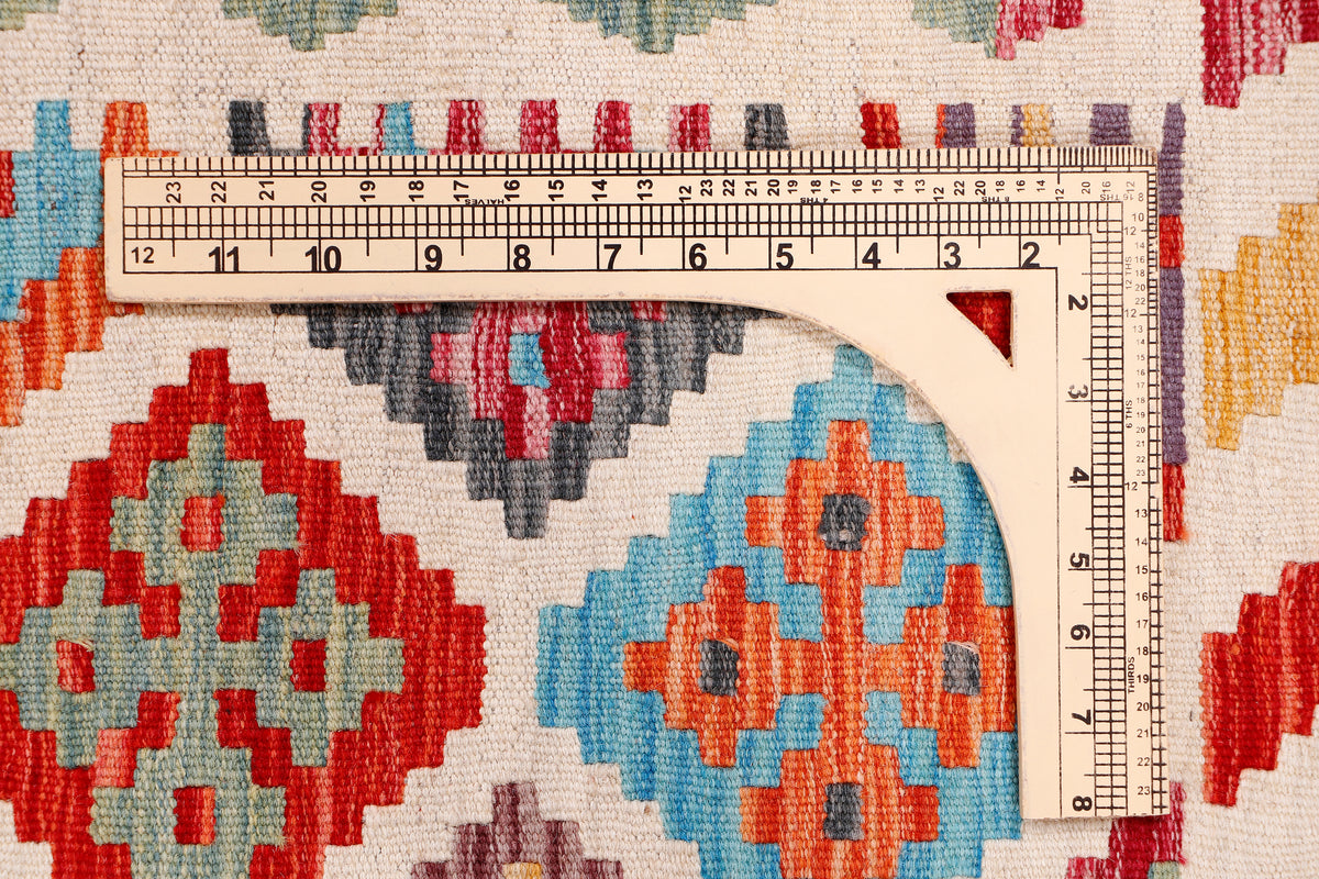 Kilim rug section with red, blue, orange and gray geometric motifs on cream