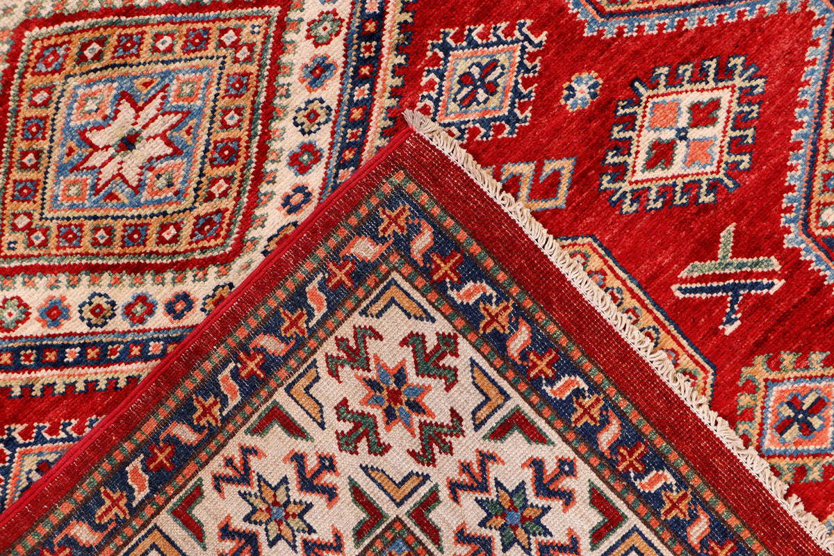 Rug corner detail with red edge, cream field, and blue geometric motifs