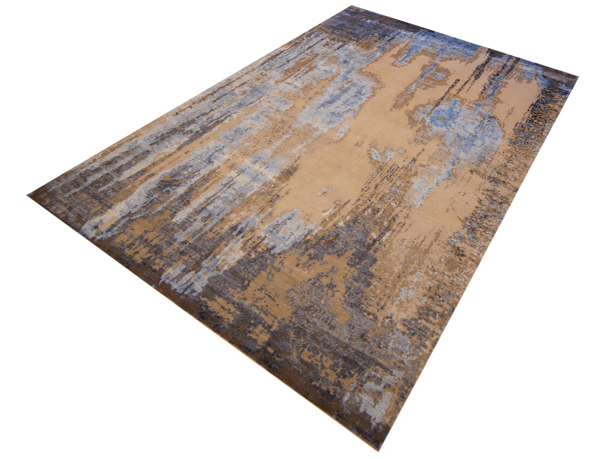 Modern Tibetan rug in beige with blue streaks and scattered dark flecks, angled view
