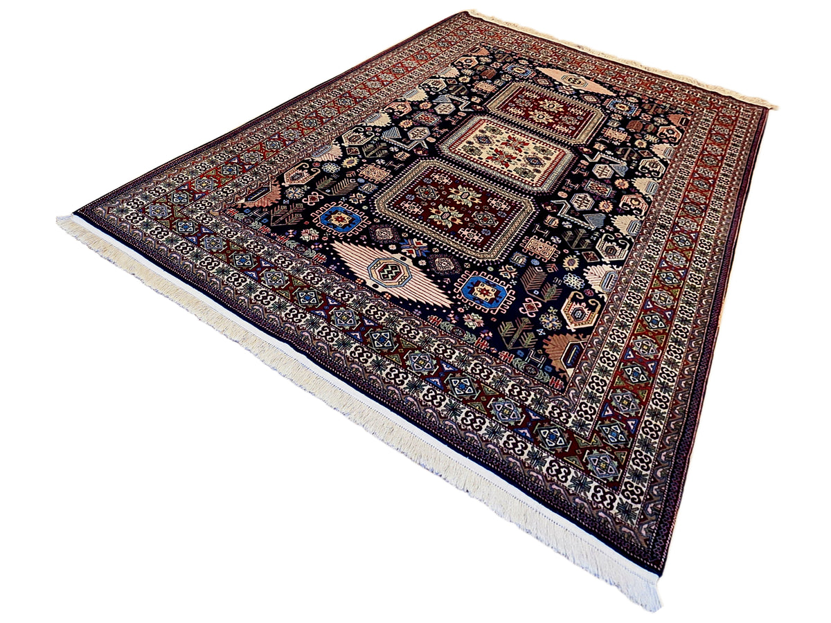 Azerbaijan rug with angled view, dark geometric center and red lattice border