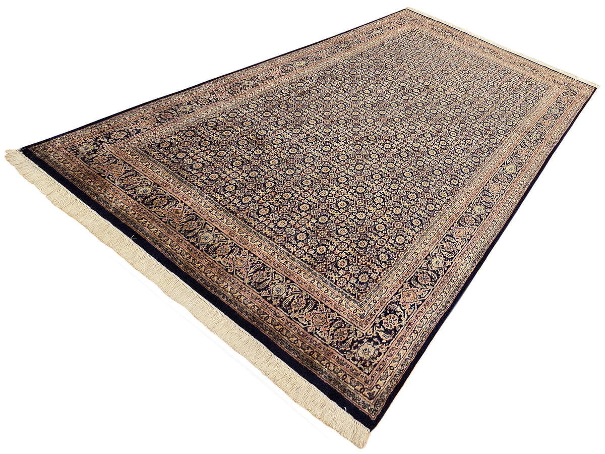 Navy and tan Bidjar-style rug with central pattern, thin border lines, and cream fringe