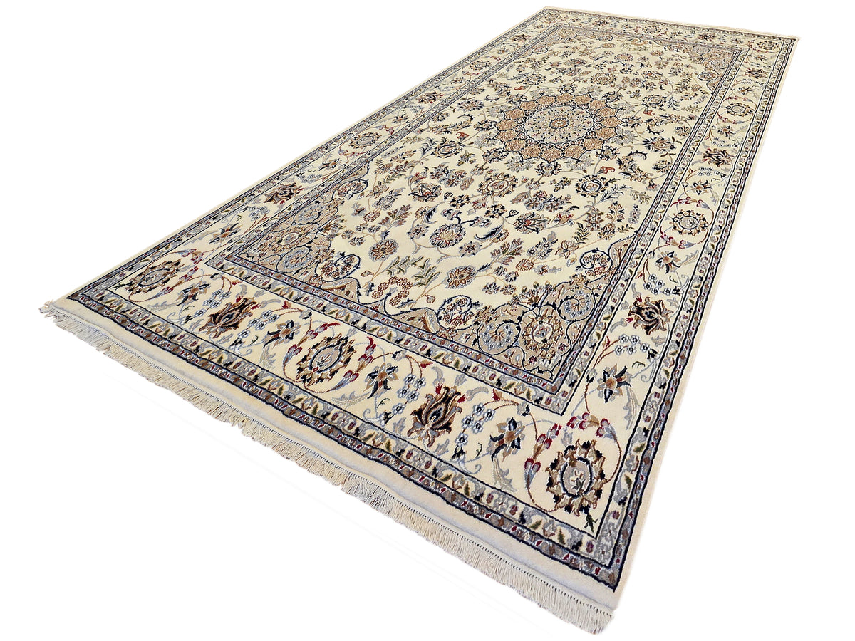 Ivory patterned area rug with blue scrolling vines, detailed border, short fringe trim.