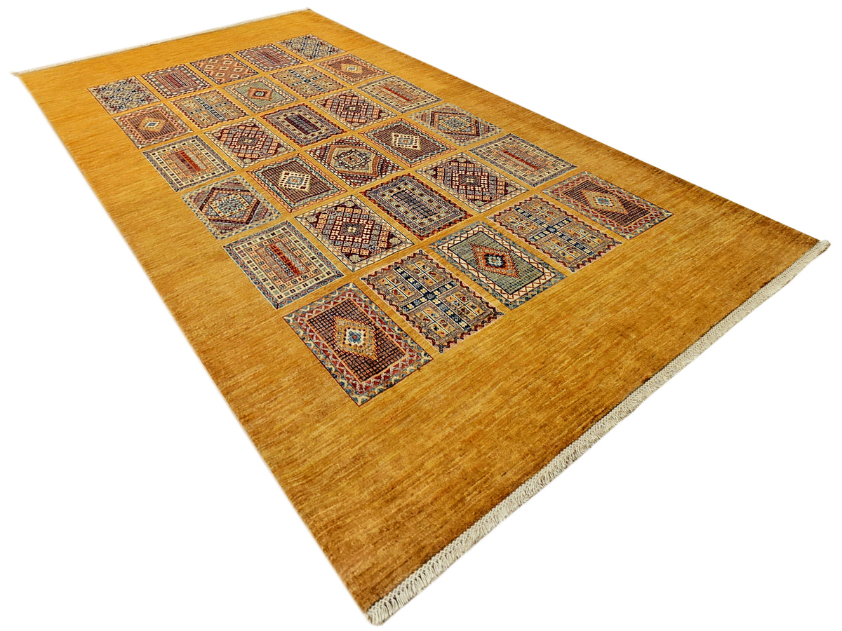 Angled view of geometric area rug with warm gold ground and multicolor diamond lattice center