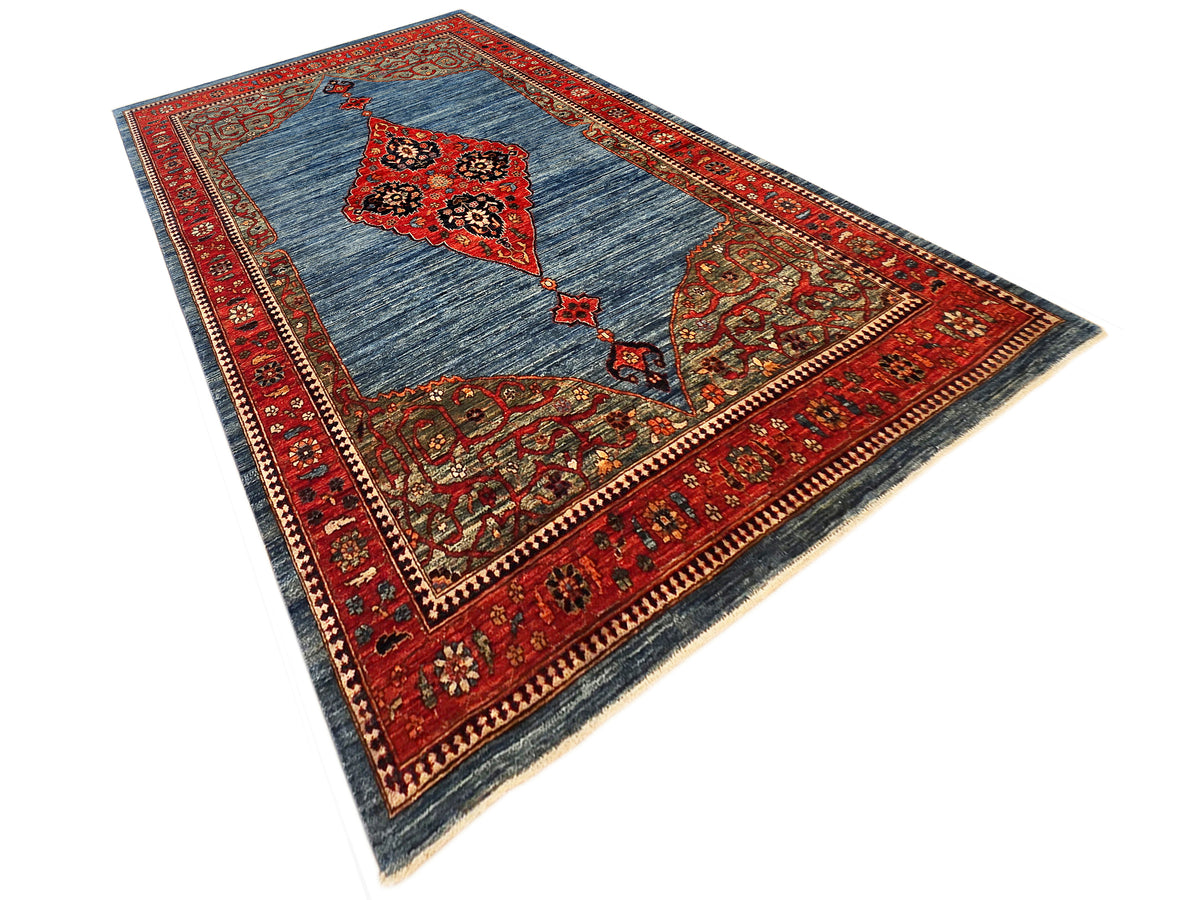 Blue and red patterned area rug with central diamond motif and decorative border.
