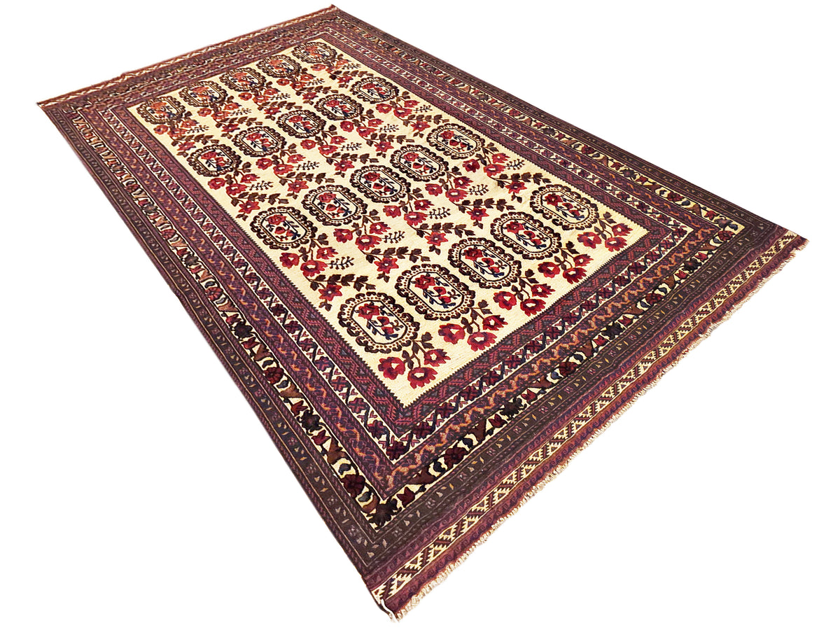 Diagonal view of rectangular area rug in cream with burgundy and navy patterned border.