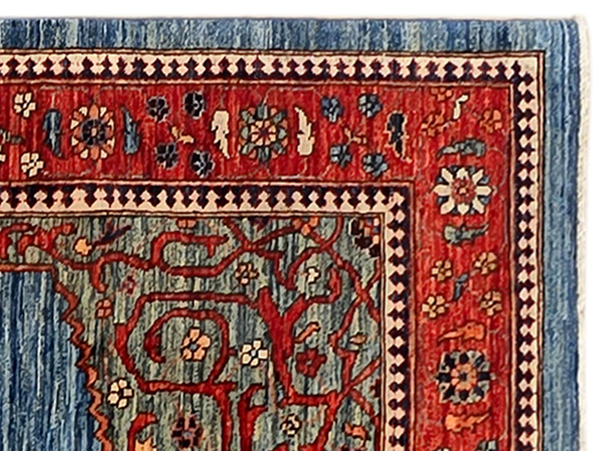 Close-up of red and blue rug panel with repeating motifs and ornamental border.