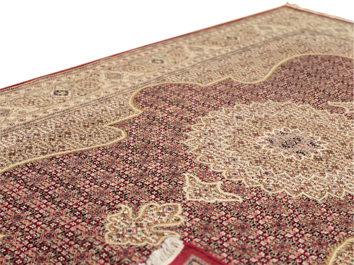 Patterned area rug with red and beige medallion motifs and ornate border