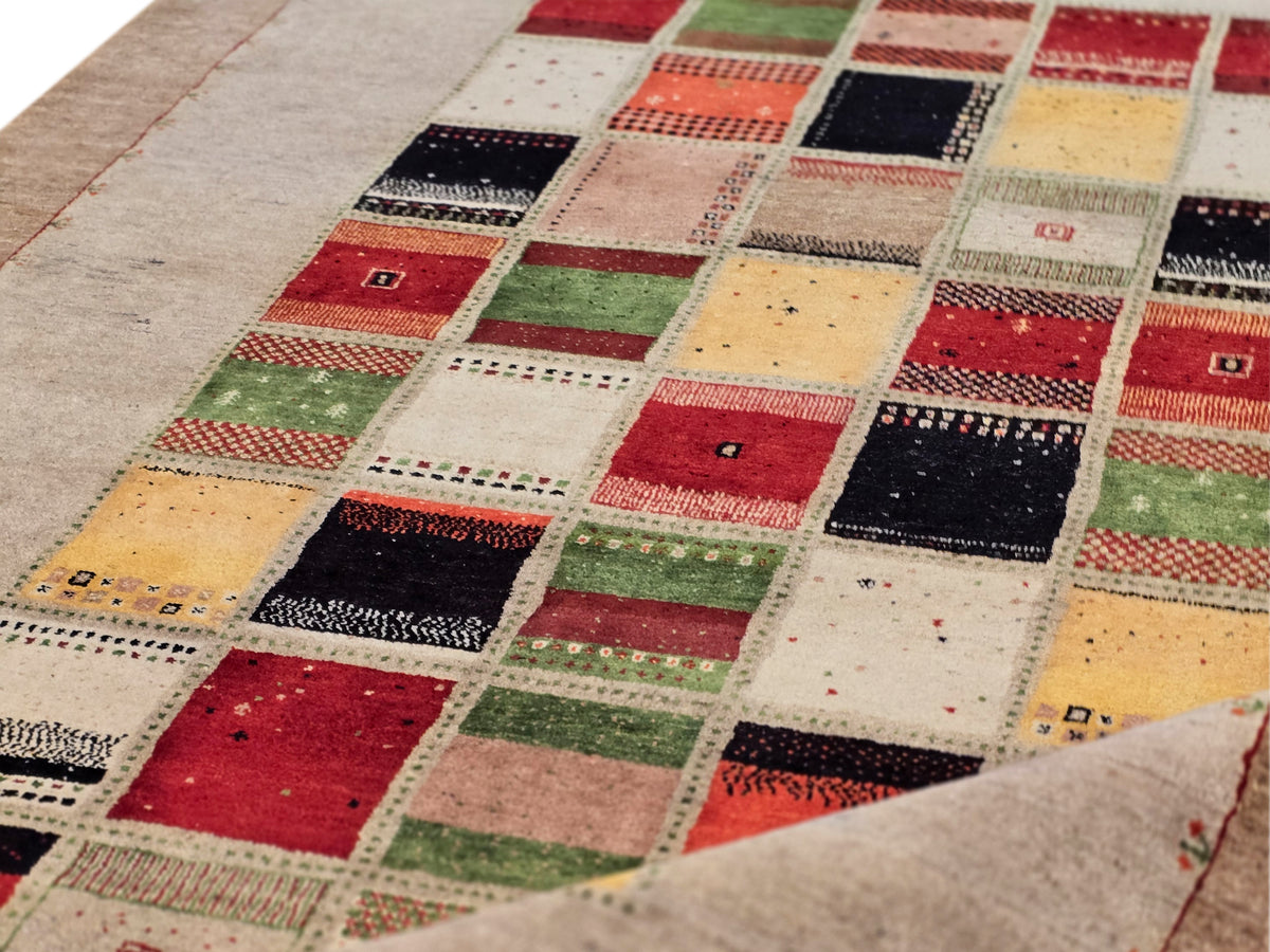 Loribaft rug close-up of multicolor square patchwork with red, green, black, beige