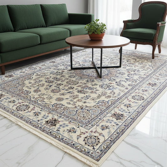 Cream and blue ornate area rug on floor with fringed border and floral medallion center.