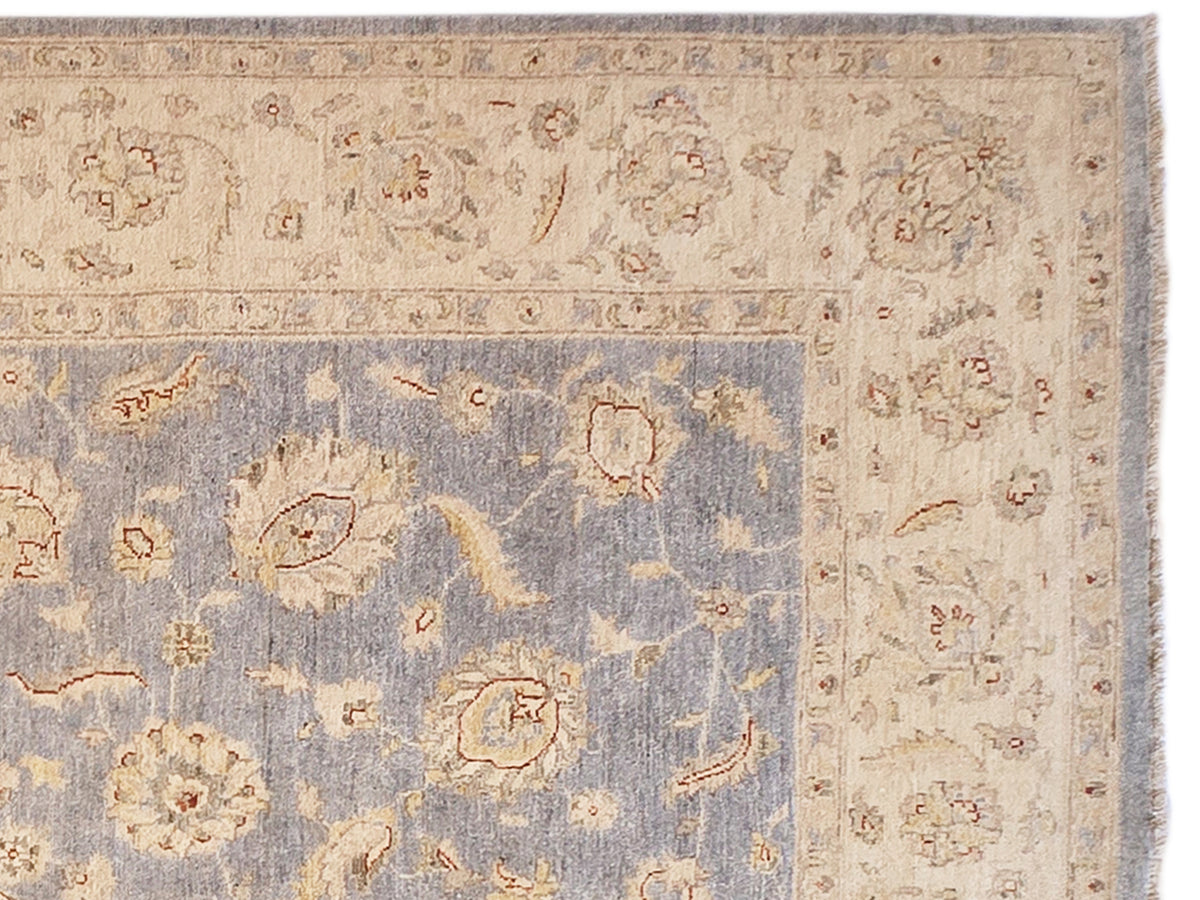 Rug detail: light blue panel with orange motif outlines and beige border, flat weave