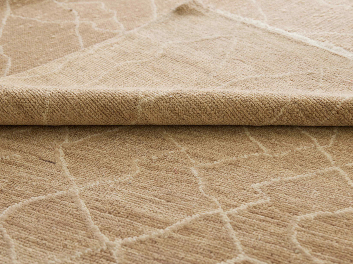 Beige rug edge detail with raised texture and crackle motif