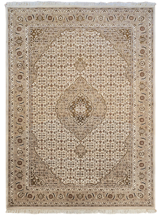 Square beige and brown patterned rug with central medallion and geometric border.