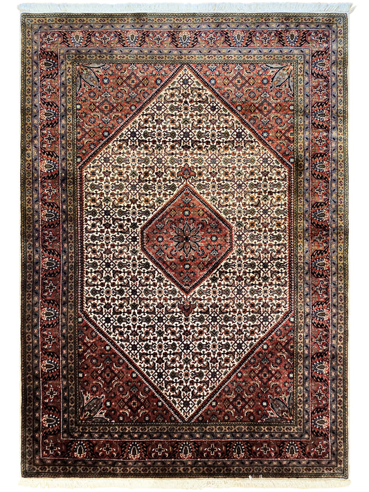 Bidjar rug with cream center medallion, red and blue geometric border, fringe.