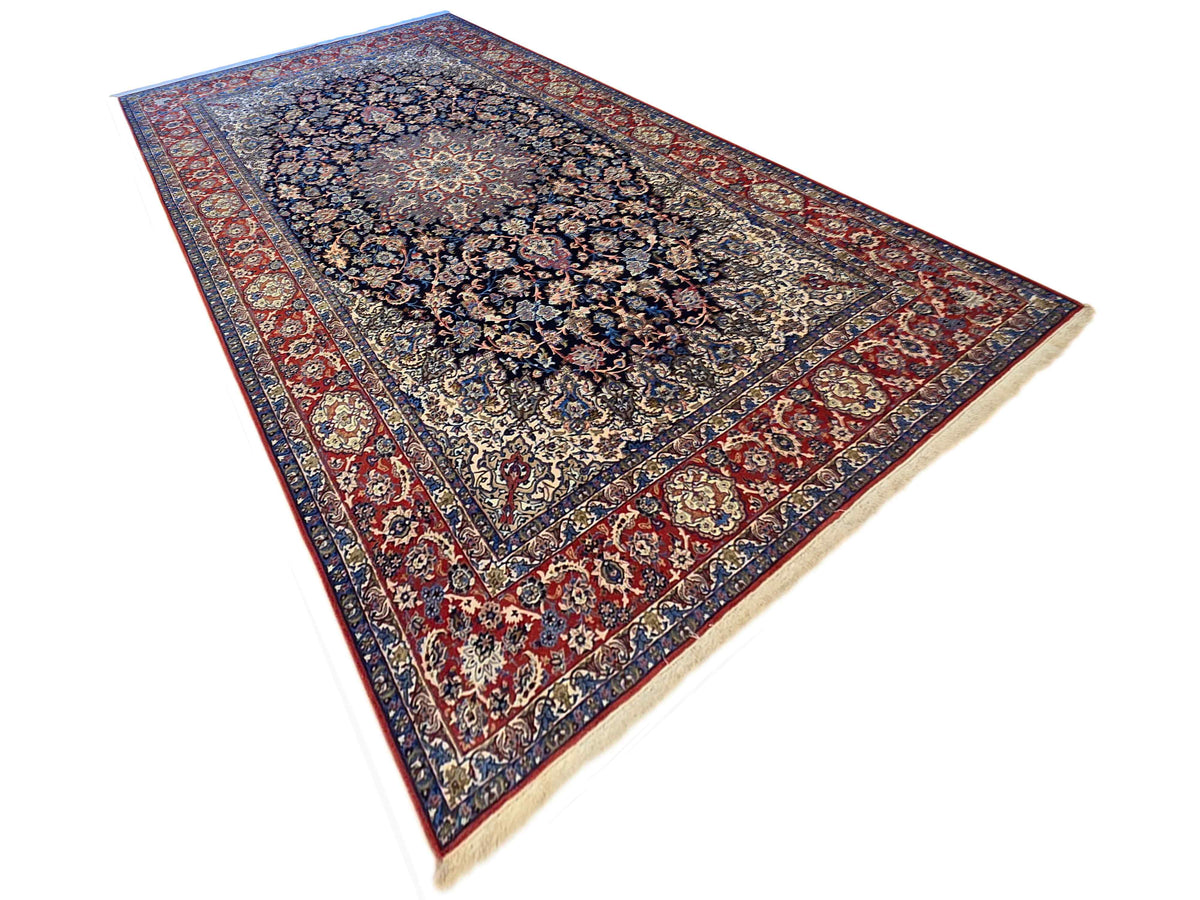 Persian-style rug with dark navy central medallion and red decorative border