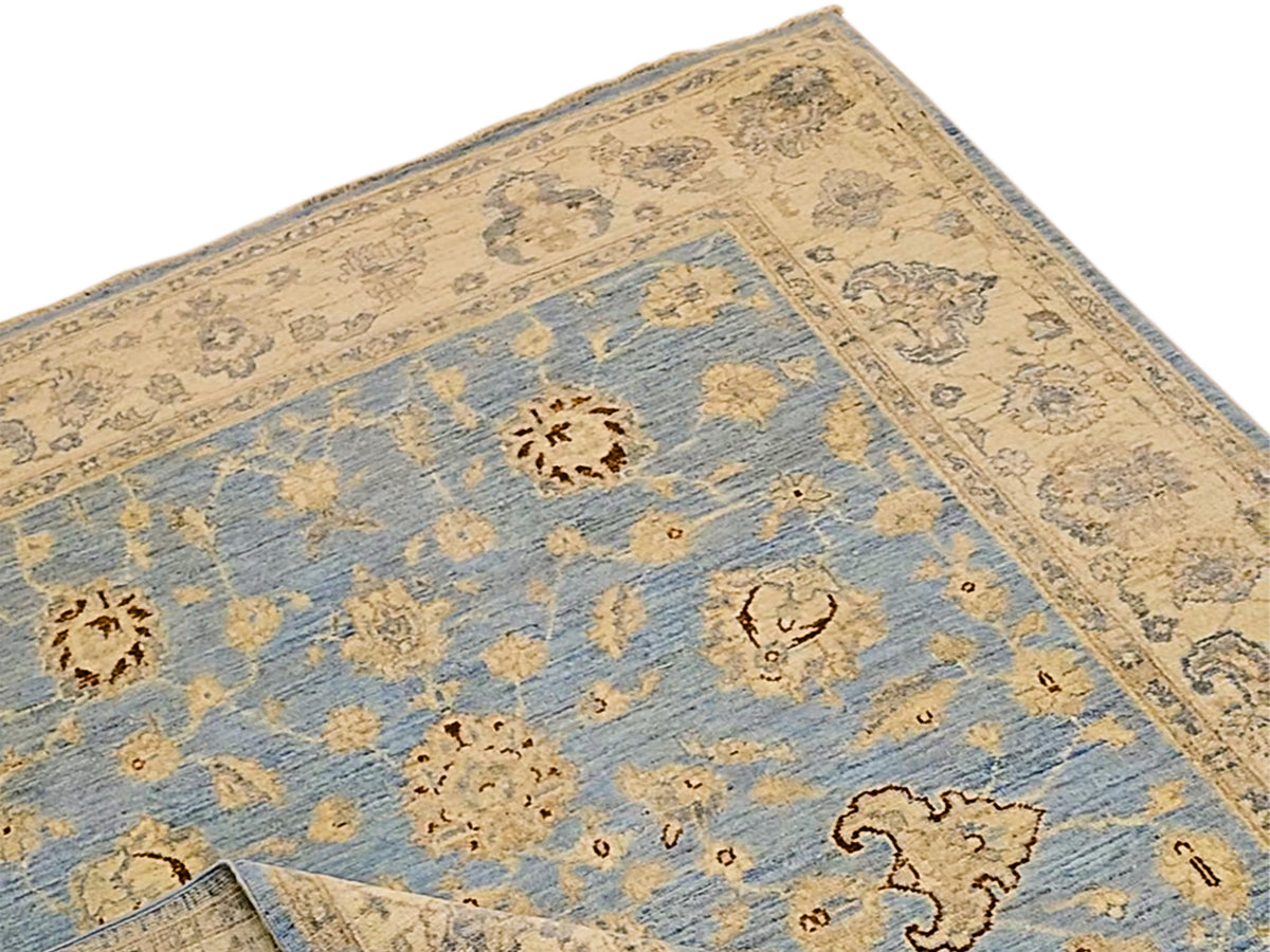 Close-up of light blue area rug with beige patterns and small ornamental medallions