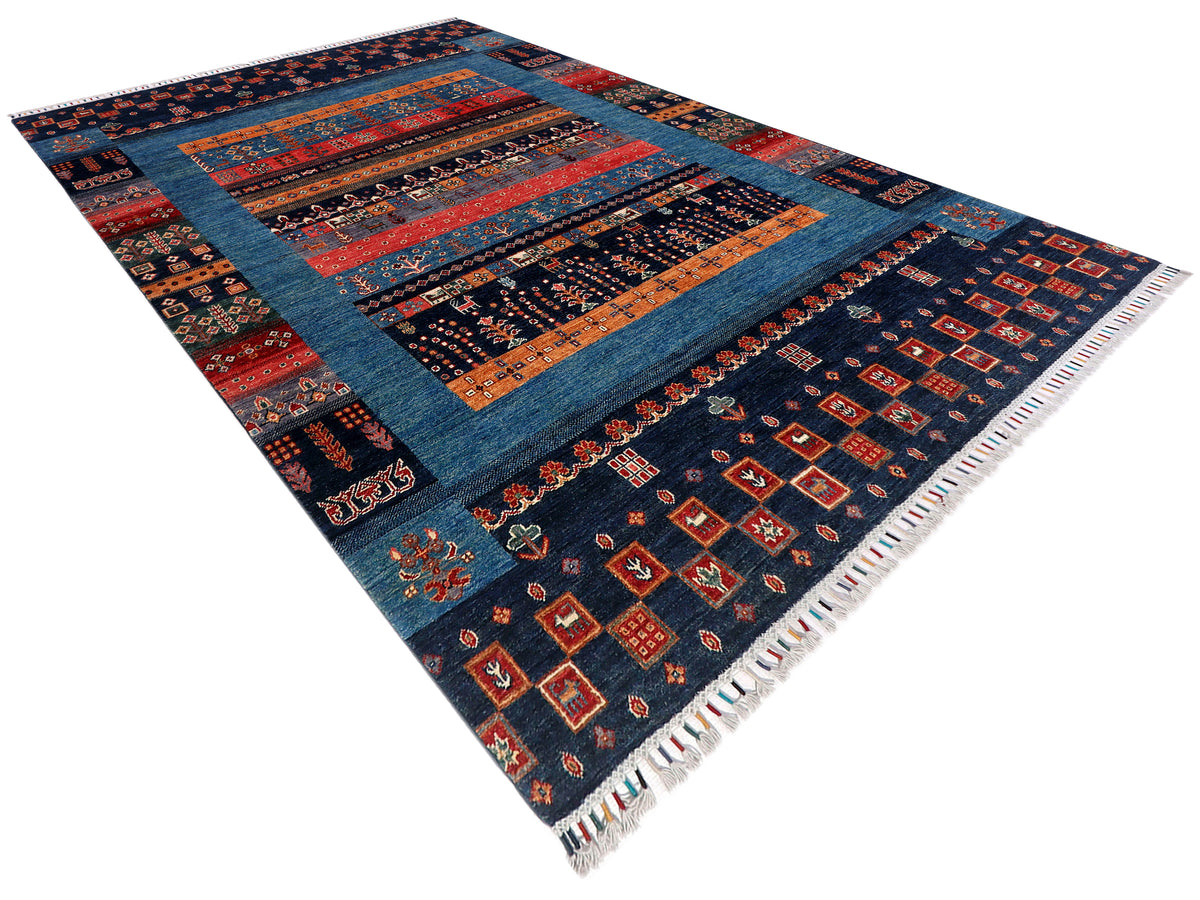 Gabbeh Afghan rug angled view with navy blue, red orange stripes, and white fringe edges