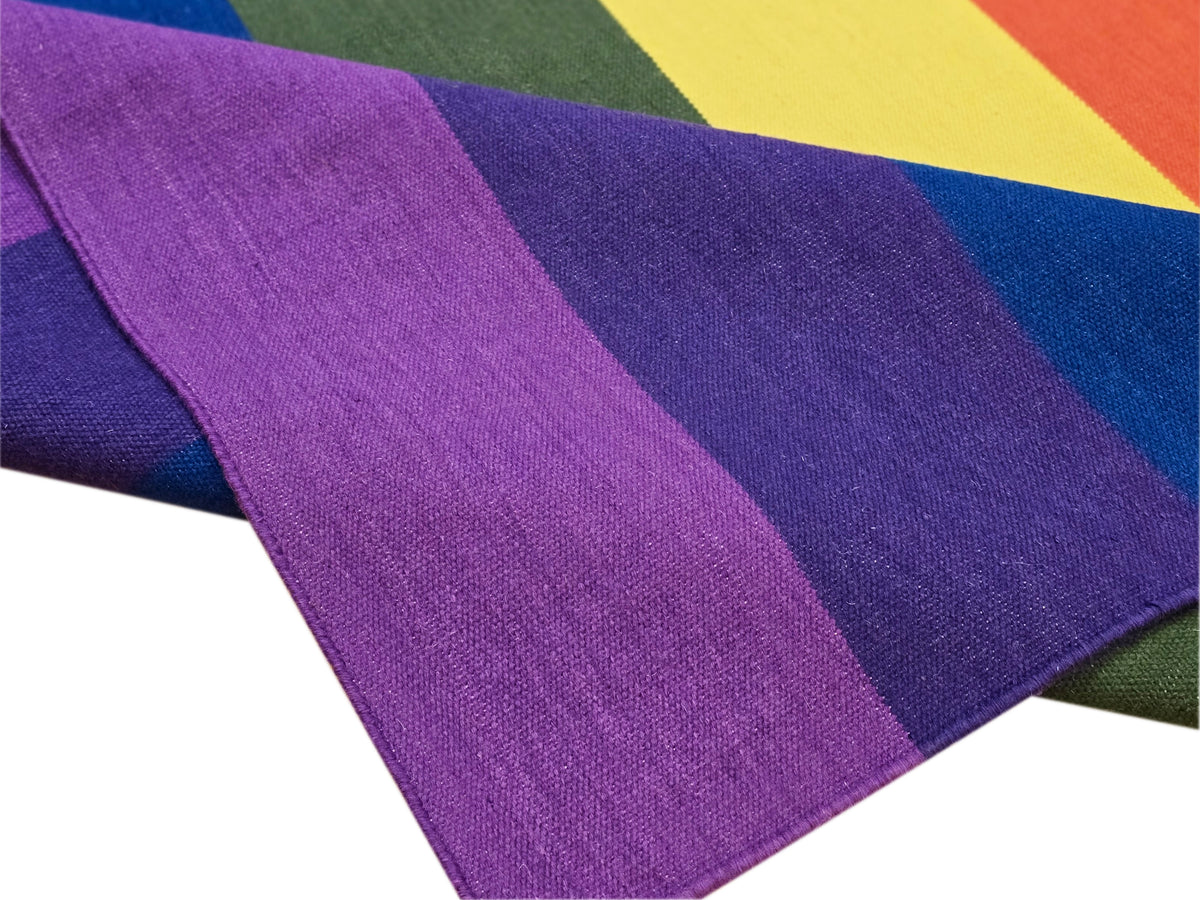 Close-up of striped rug texture with purple, blue, green, and yellow woven bands