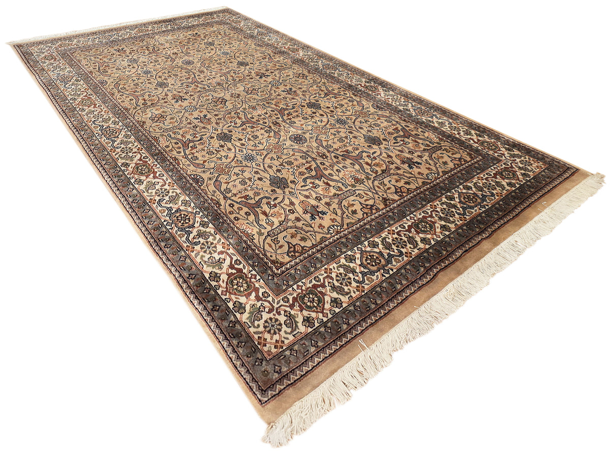 Khashan rug with beige center, dark geometric border, and light fringe