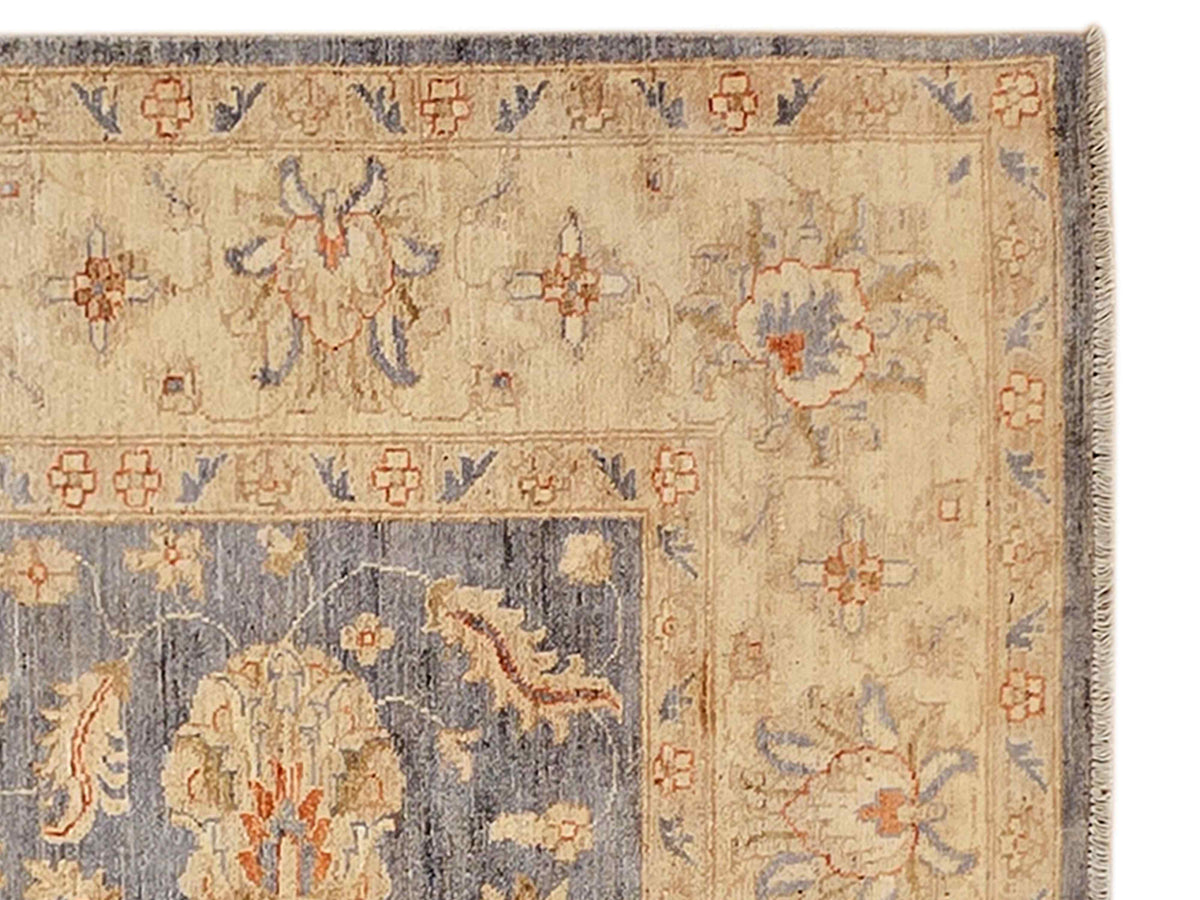 Rug detail with beige field, blue accents, floral motifs, and woven fringe border