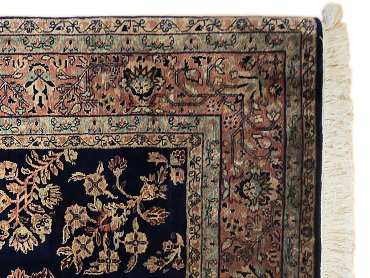 Navy Sarouk rug corner detail with dense gold motifs and cream, blue, rust borders