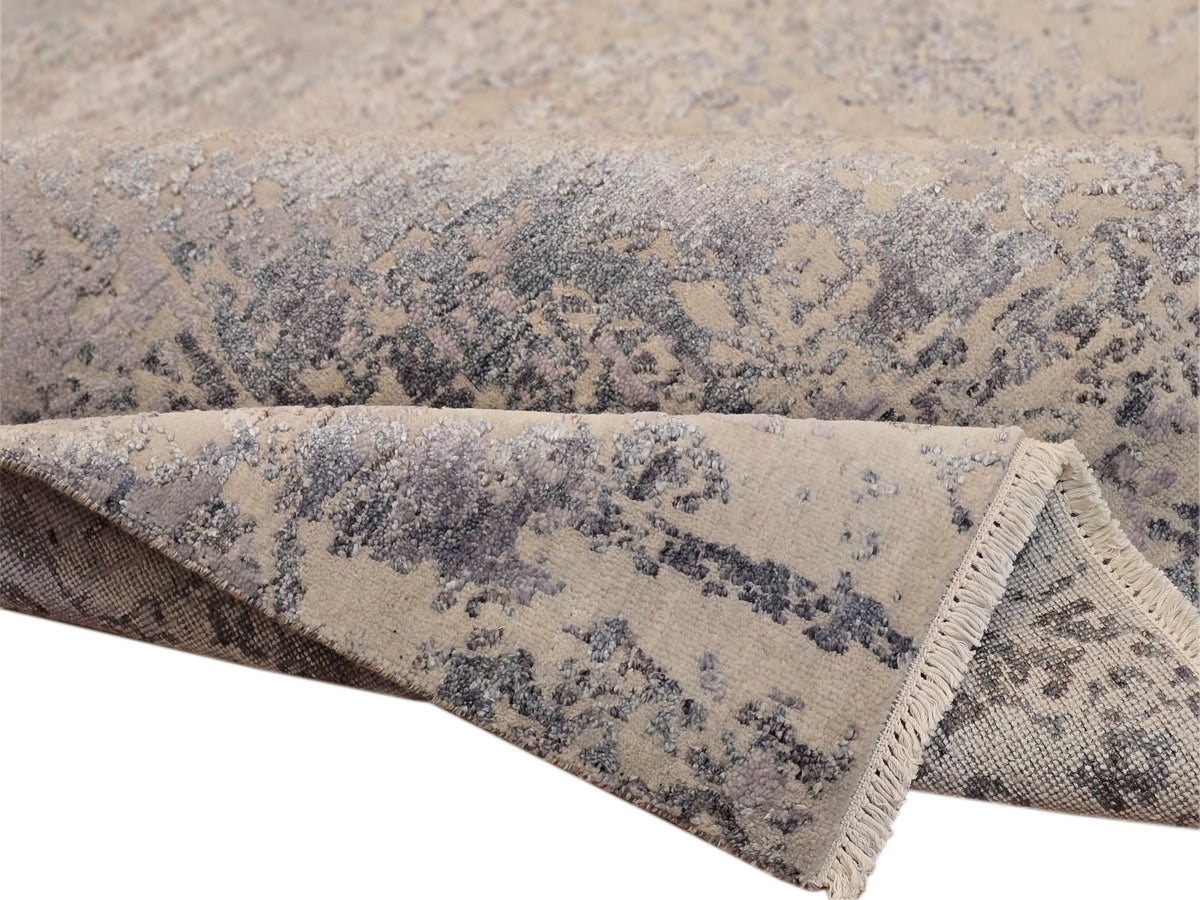 Modern area rug border close-up, abstract blue-gray pattern with short fringe
