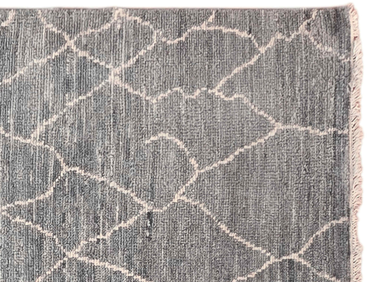 Close-up of grey rug with crackled trellis pattern and light beige linework.