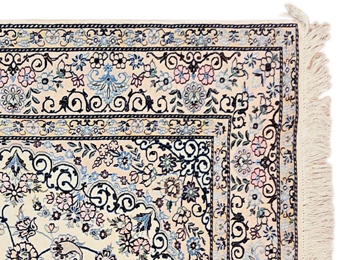 Blue, cream and pink floral pattern area rug corner with fringe edge detail