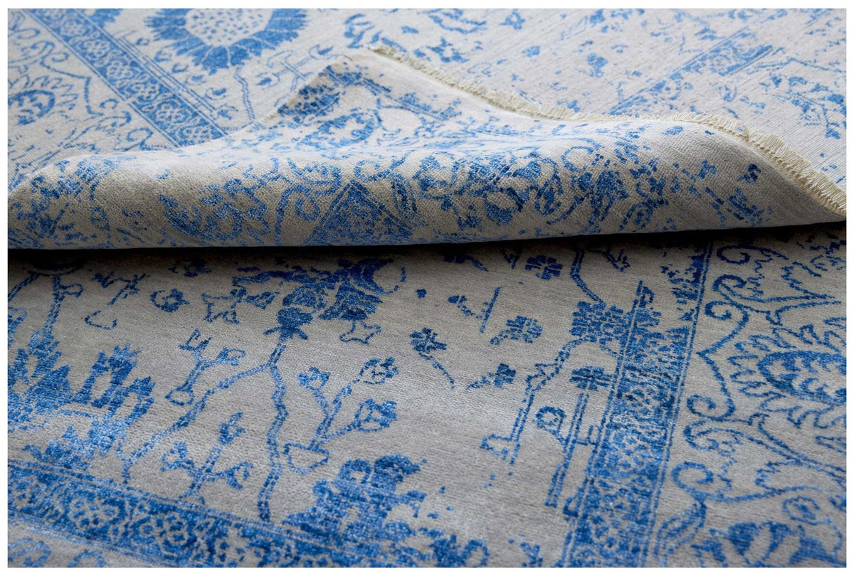 Blue and white patterned rug with folded texture detail and visible weave