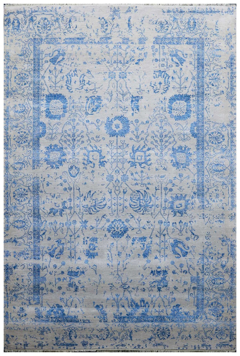Blue and white ornate patterned area rug with border and fringe