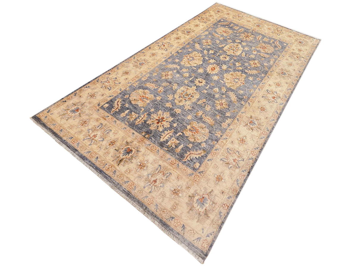 Rectangular area rug in beige with blue medallion panel and ornate floral border