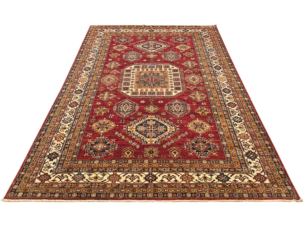 Red area rug with centered medallion, cream paneling, and detailed geometric border