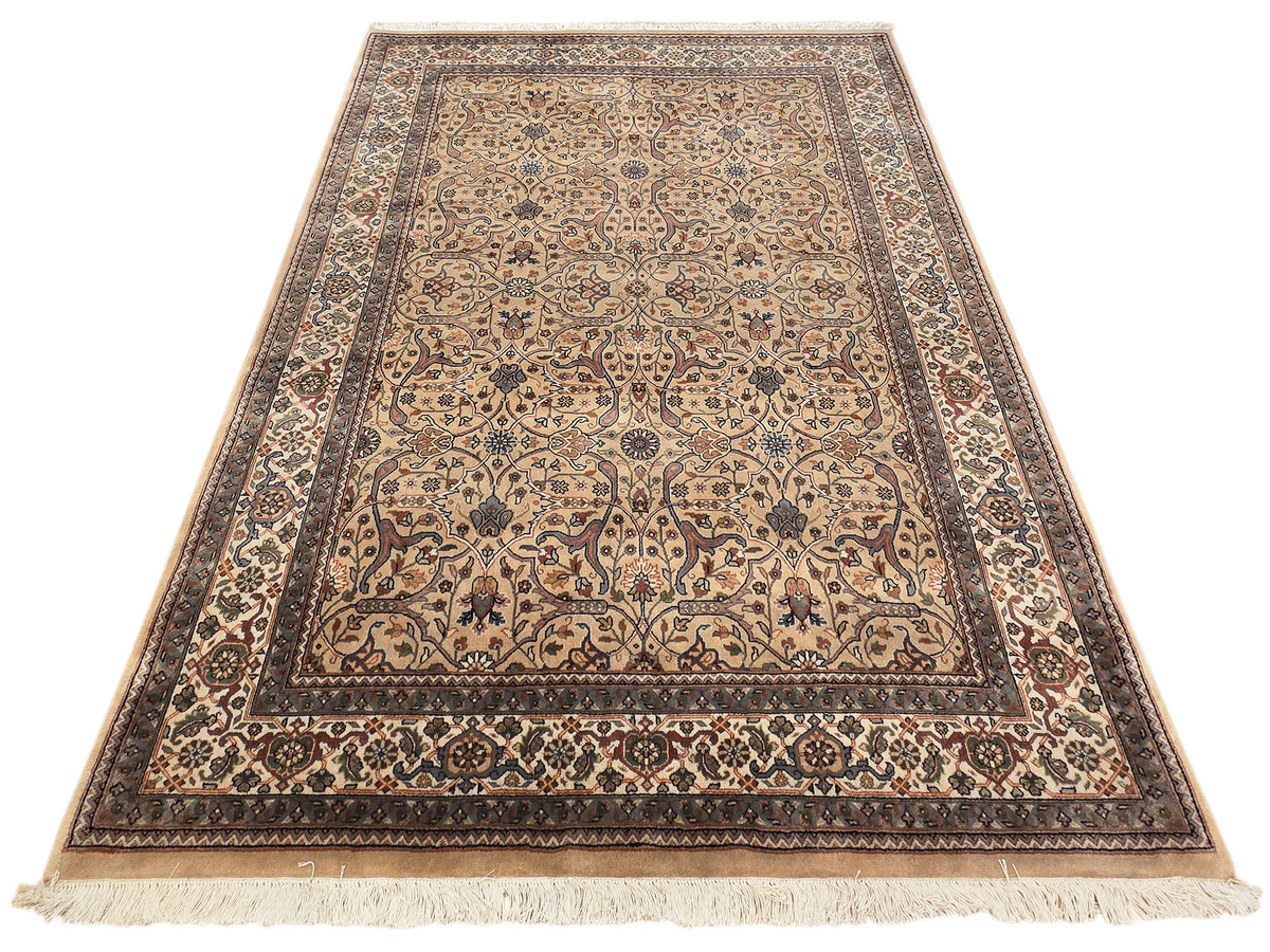Khashan rug with beige center panel, floral motifs, and fringed border