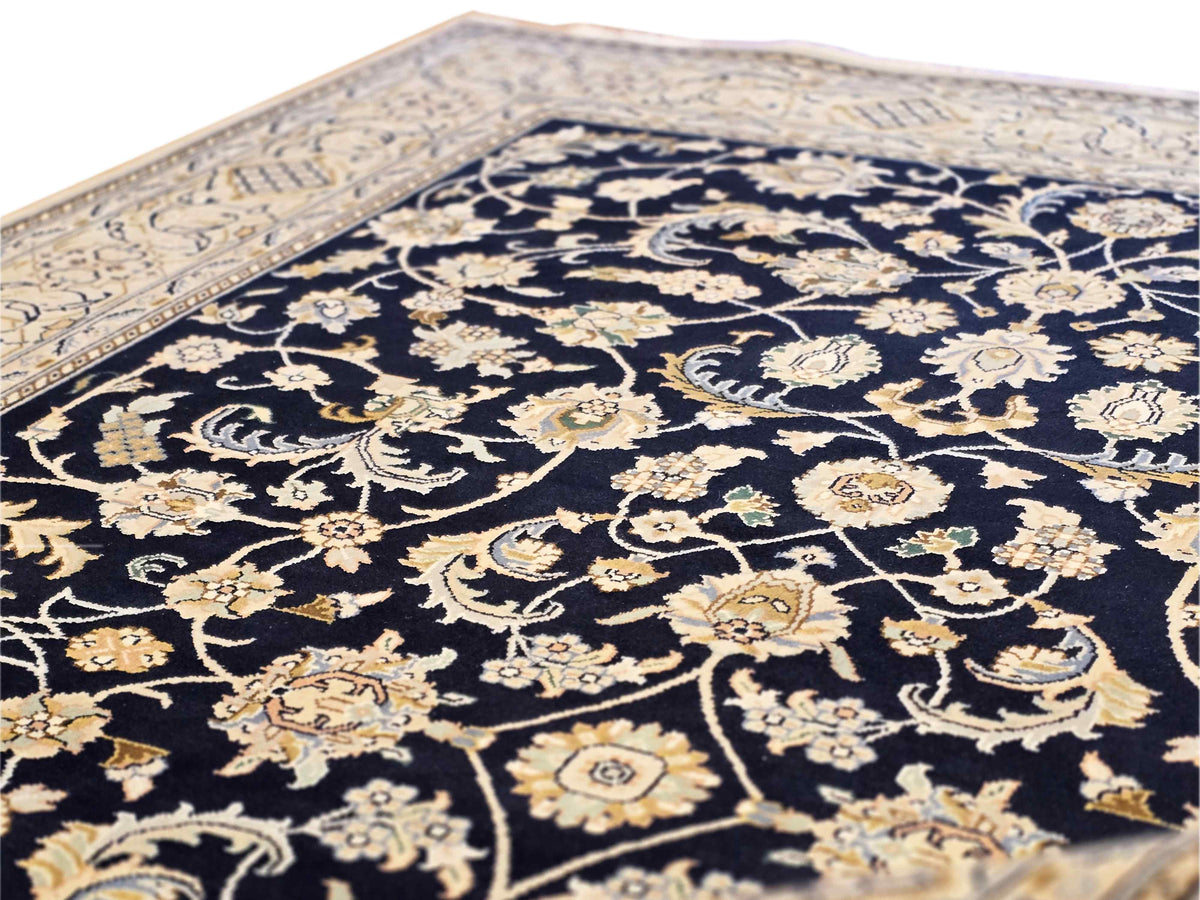 Close-up of navy Nain rug with cream and gold floral scrolling details