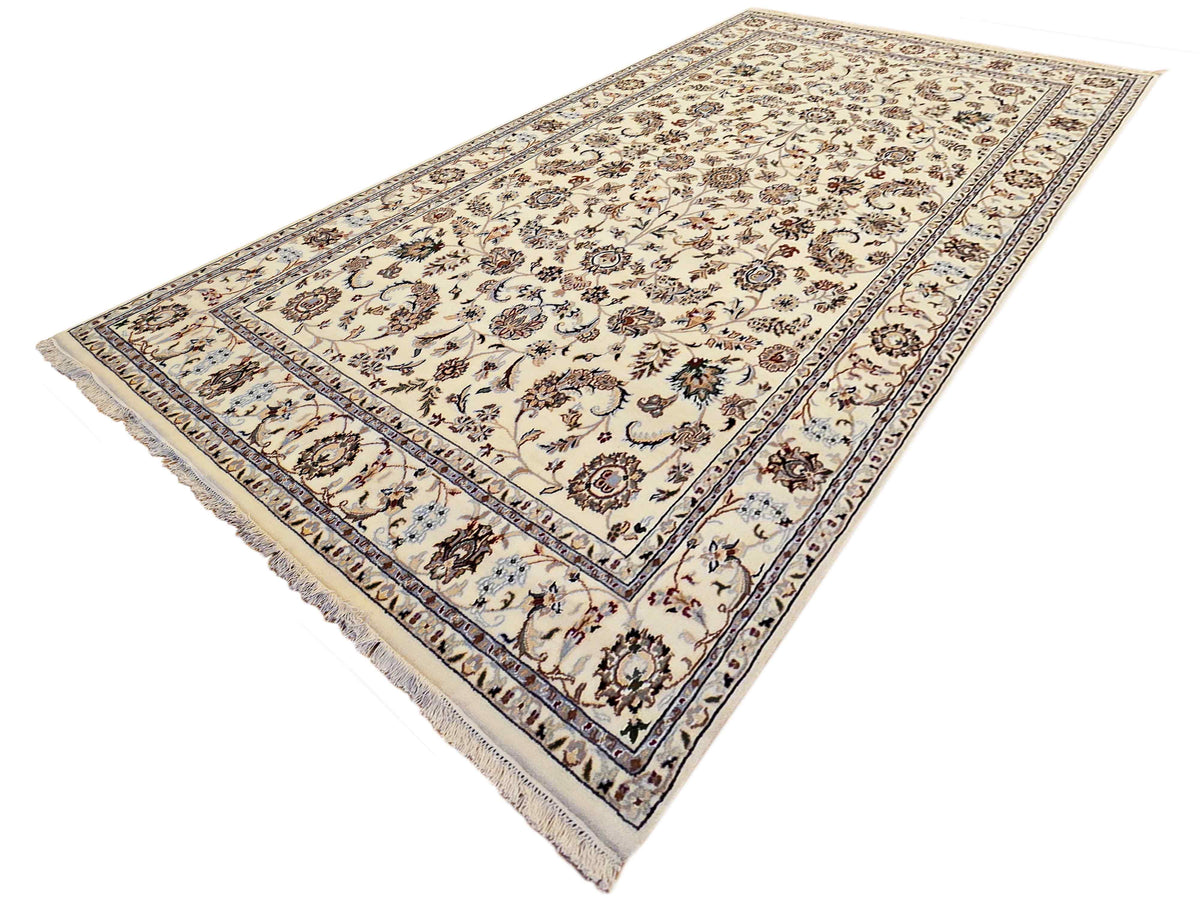 Cream rug with detailed botanical motifs and blue edge stripes, visible fringed border