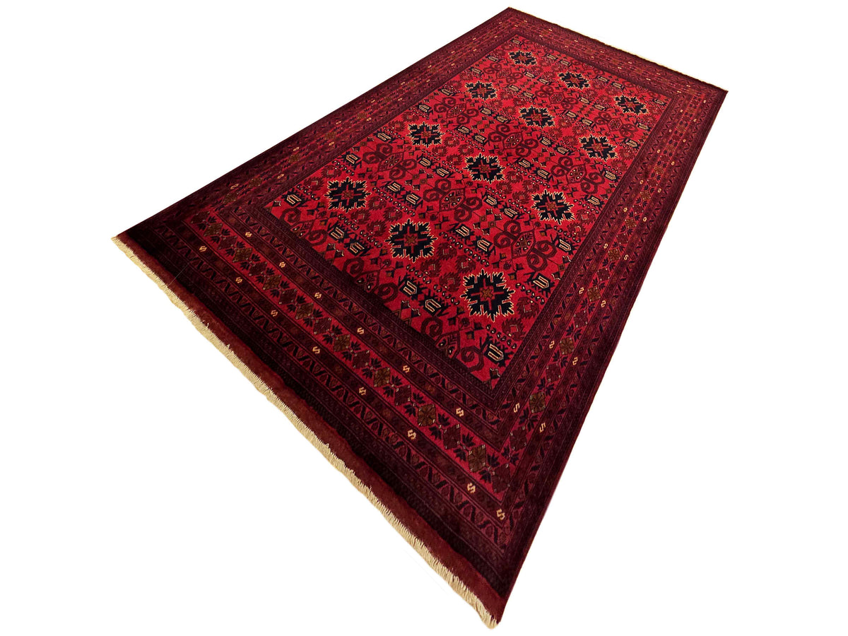 Red patterned area rug with central medallion, contrasting border, and fringe edge