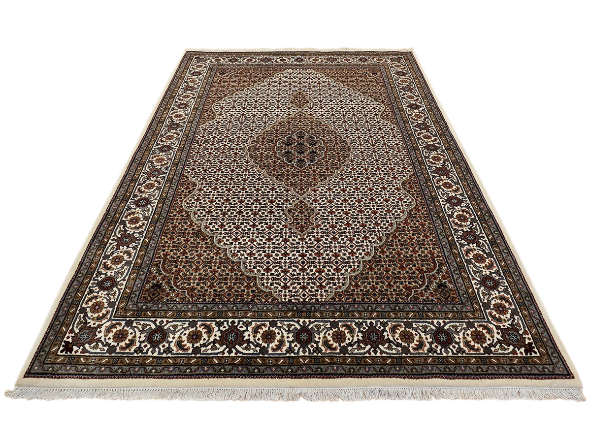Flat patterned area rug with brown field, ivory floral medallion, and decorative border.