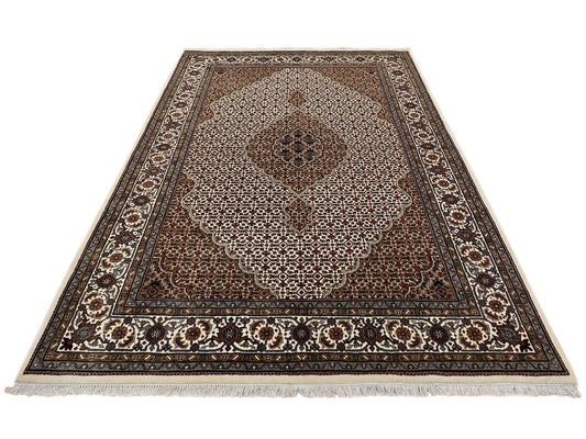 Rectangle oriental rug with brown center, cream speckled pattern, and dark geometric border