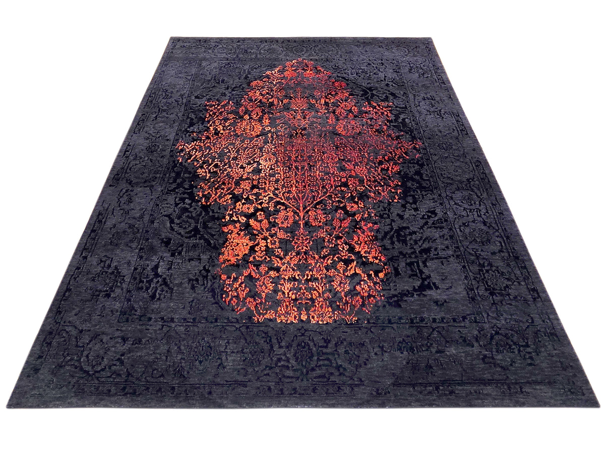 Navy textured rug with orange-red abstract medallion, angled top view