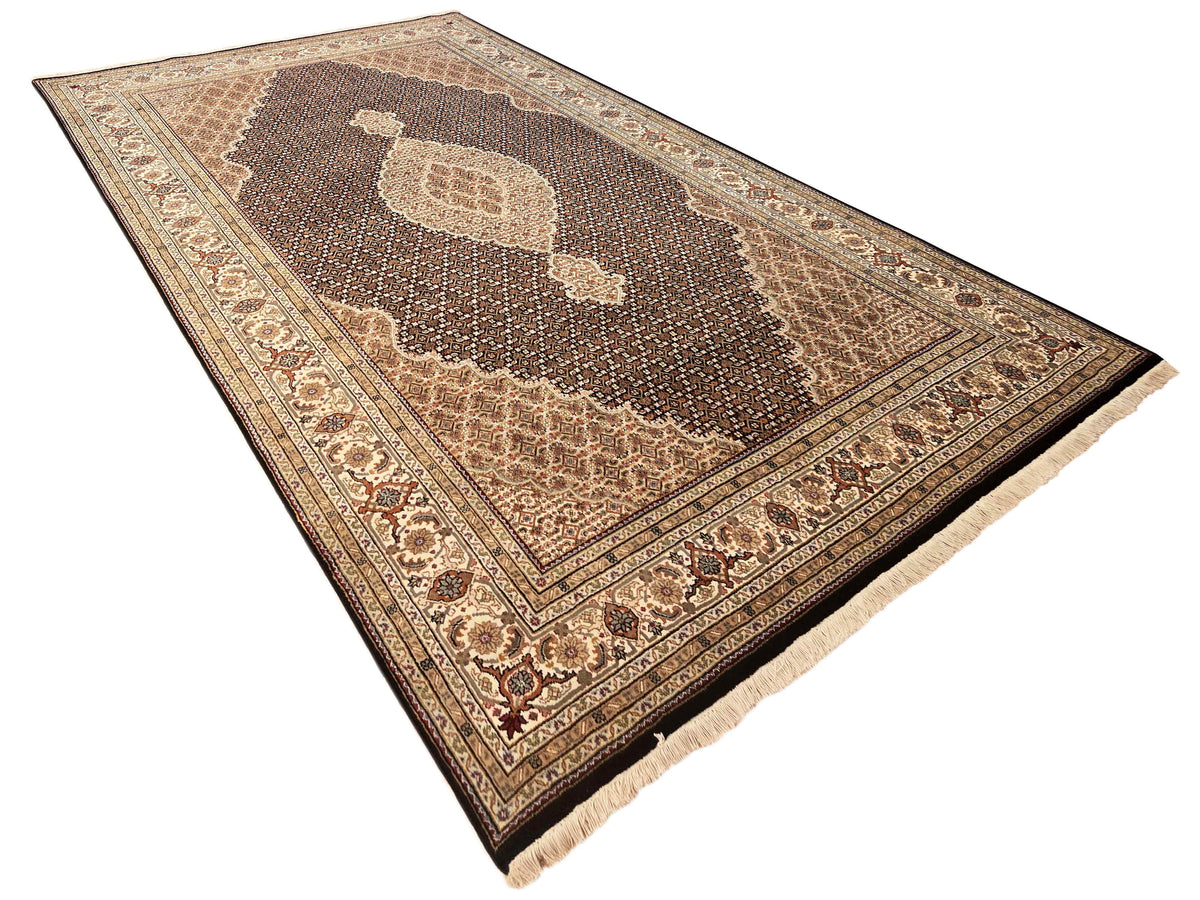 Large Tabriz mahi rug with brown field, cream border, and central decorative shapes