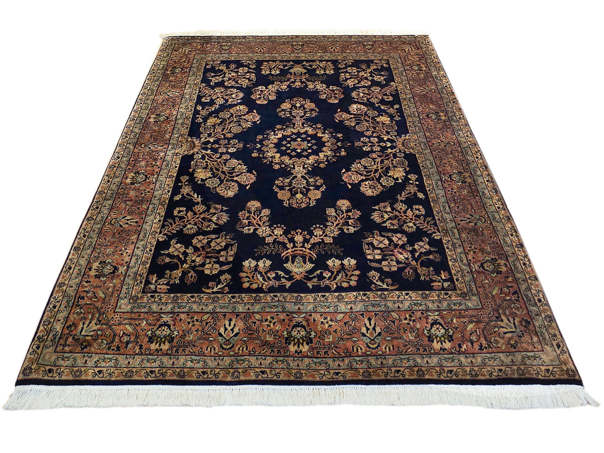 Sarouk rug with navy center medallion, rust and beige border panels, fringed ends