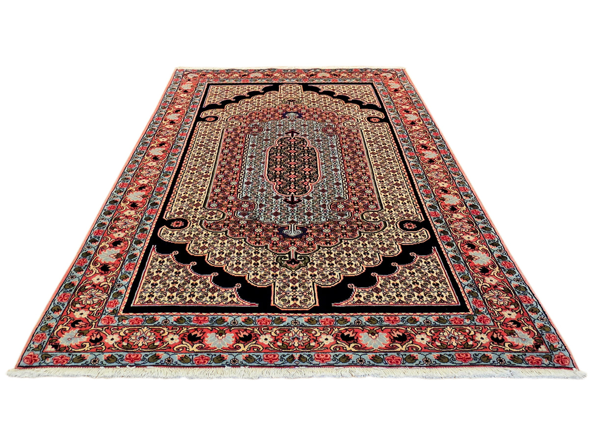 Symmetrical Persian-style area rug with central medallion and red, navy, cream accents.