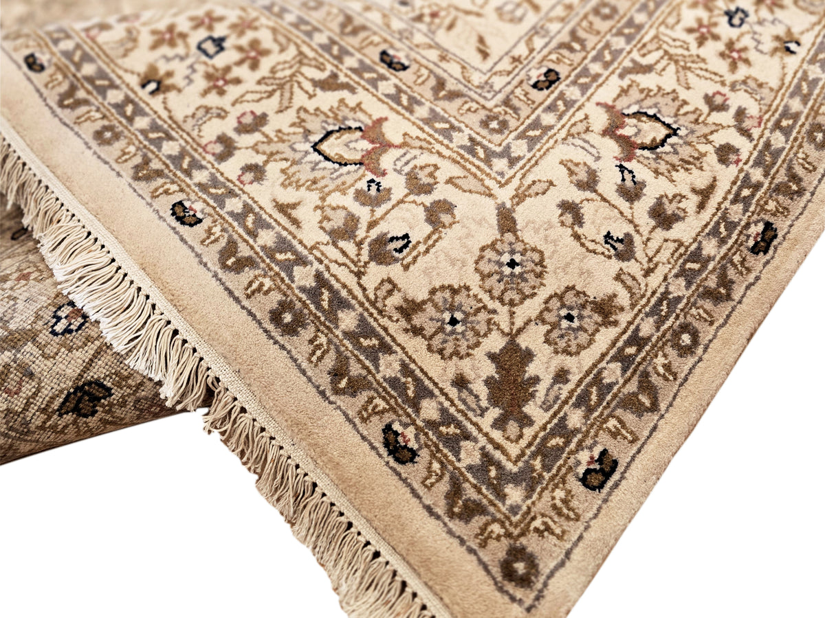 Bakhtiar rug corner detail with beige ground, dark motifs, and short fringe along edge.