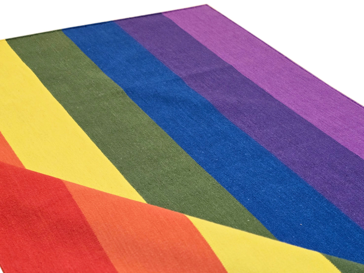 Rug with bold rainbow-like stripe bands in purple, blue, green, yellow, and red hues