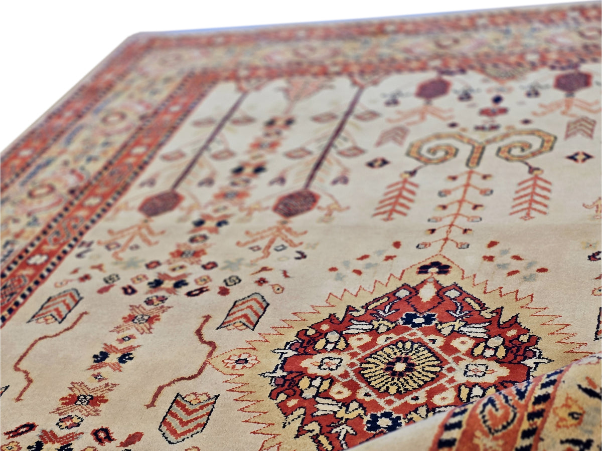 Close-up rug section with cream base, dark blue accents, and red pattern motifs