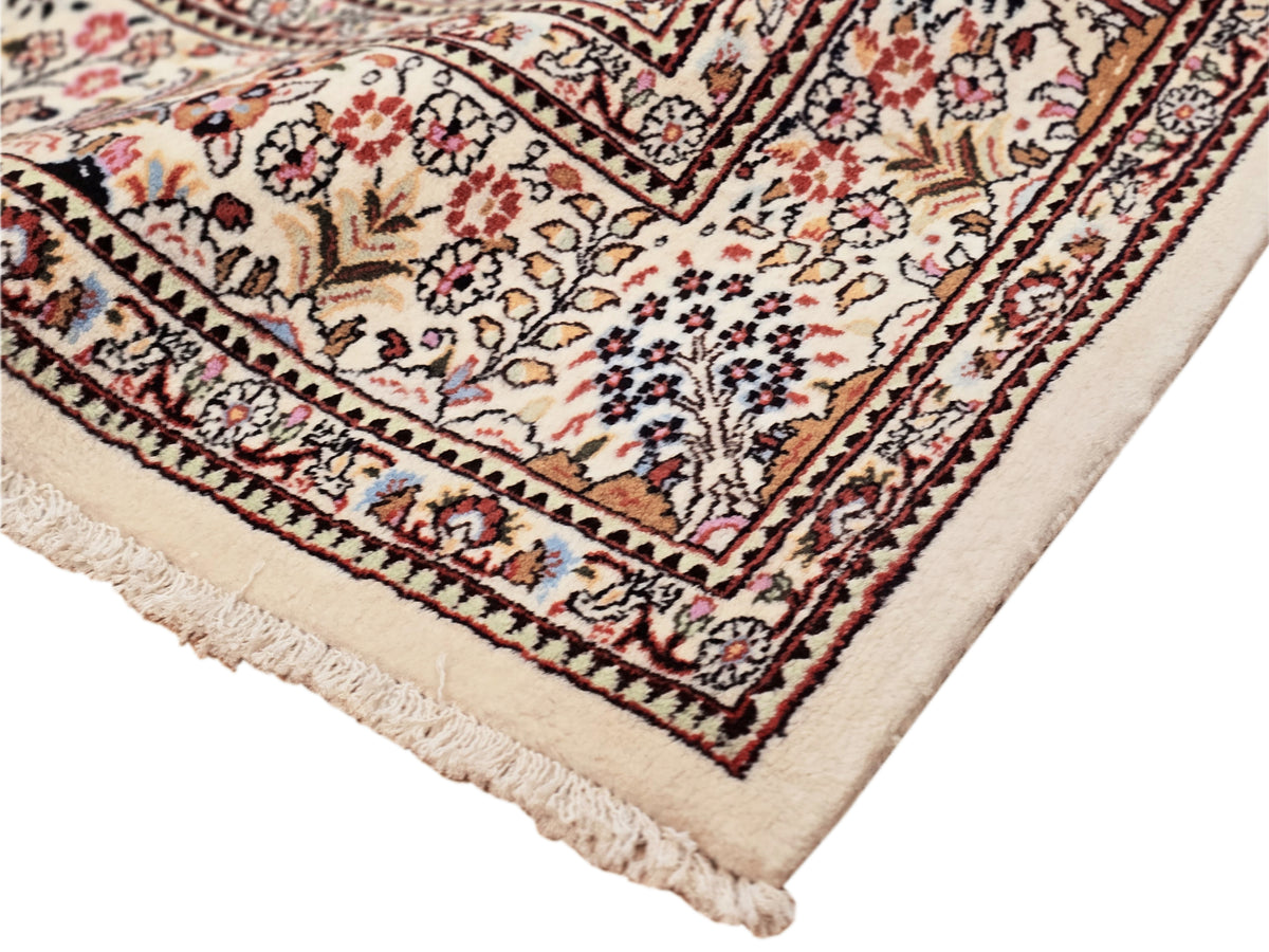 Multicolor patterned area rug corner with short fringes and detailed border trim.